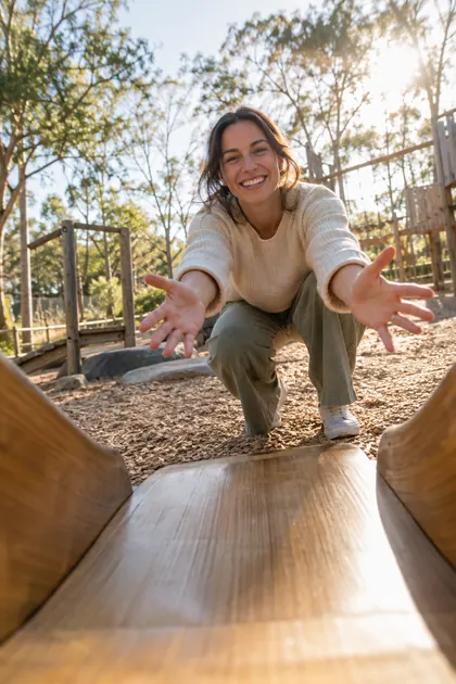 Looking up from the bottom of a slide at a caregiver with open arms